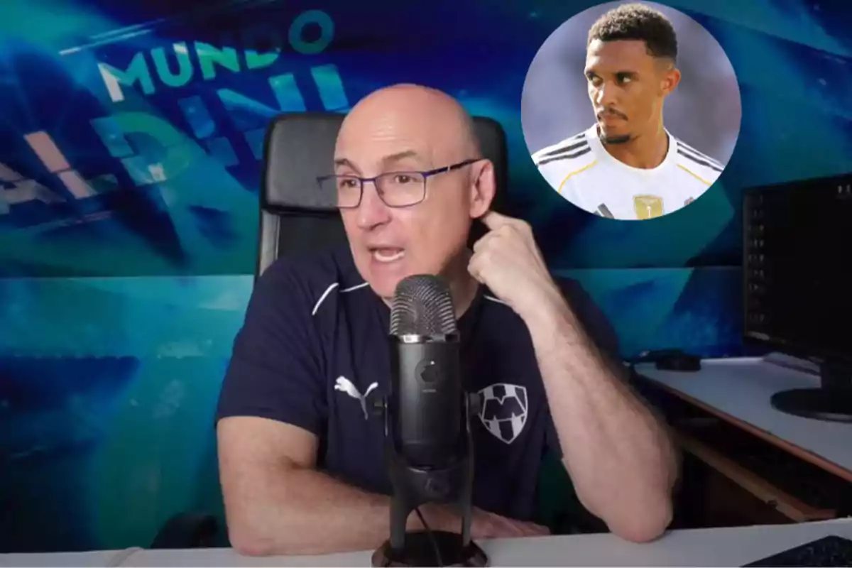 Hombre calvo con gafas y camiseta de Rayados hablando frente a un micrófono con fondo azul y la imagen de un futbolista en la esquina superior derecha