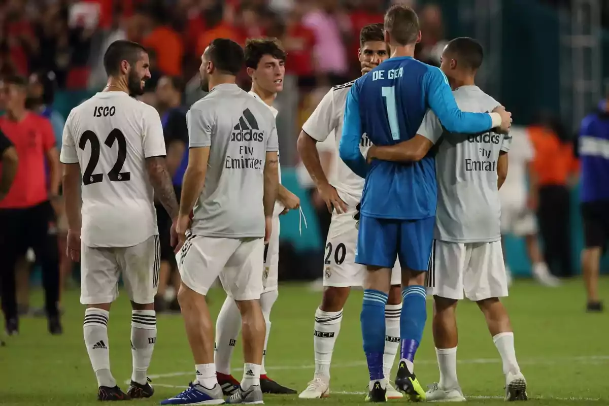 Several players talk and hug on the field after a match. Several players talk and hug on the field after a match.