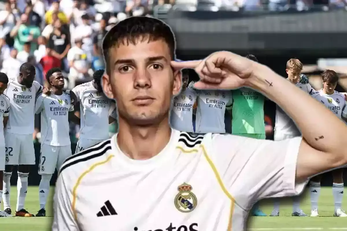 Jugador del Real Madrid en primer plano celebrando con gesto de señalar la cabeza mientras al fondo el equipo está reunido en el campo antes de un partido