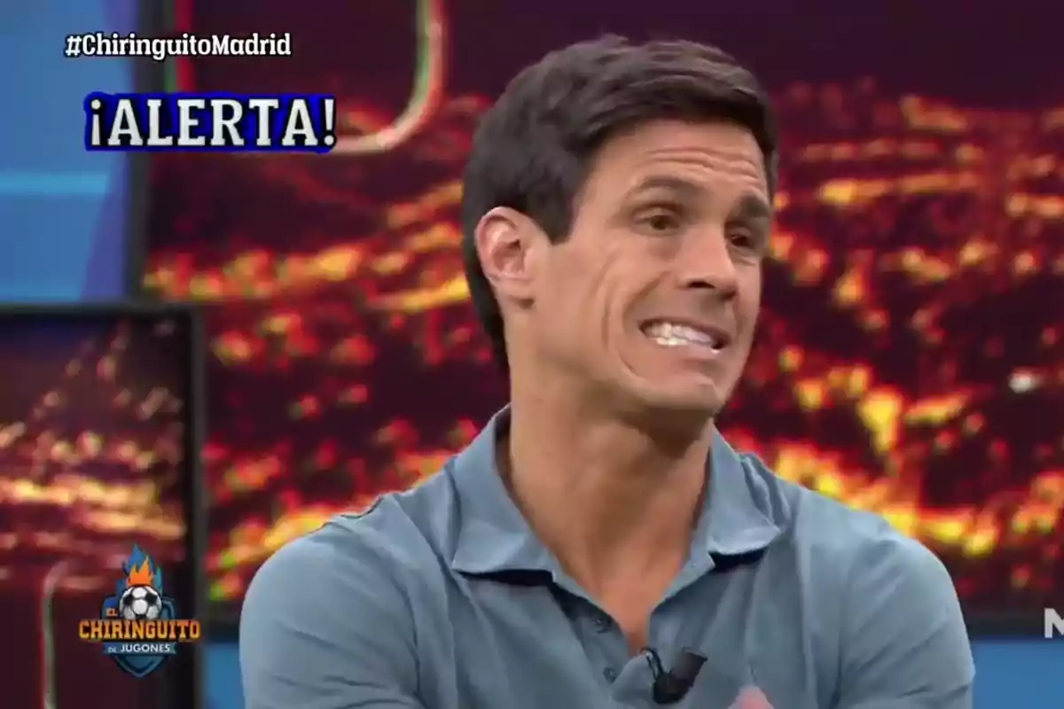 Hombre con expresión de incomodidad en un programa de televisión con el texto alerta en la pantalla