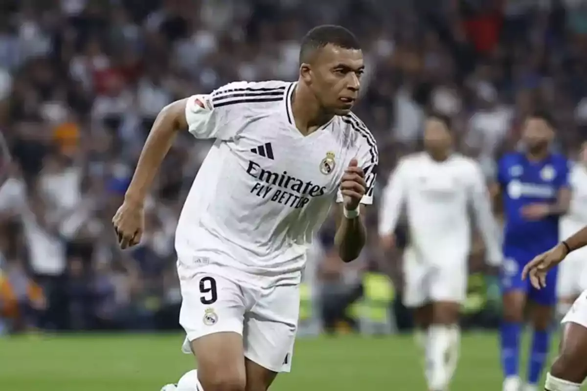 Futbolista con uniforme blanco del Real Madrid corriendo en el campo durante un partido Futbolista con uniforme blanco del Real Madrid corriendo en el campo durante un partido