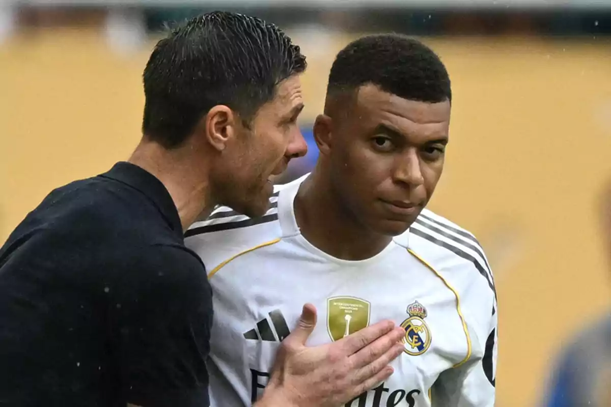 Entrenador hablando al oído de un futbolista del Real Madrid durante un partido