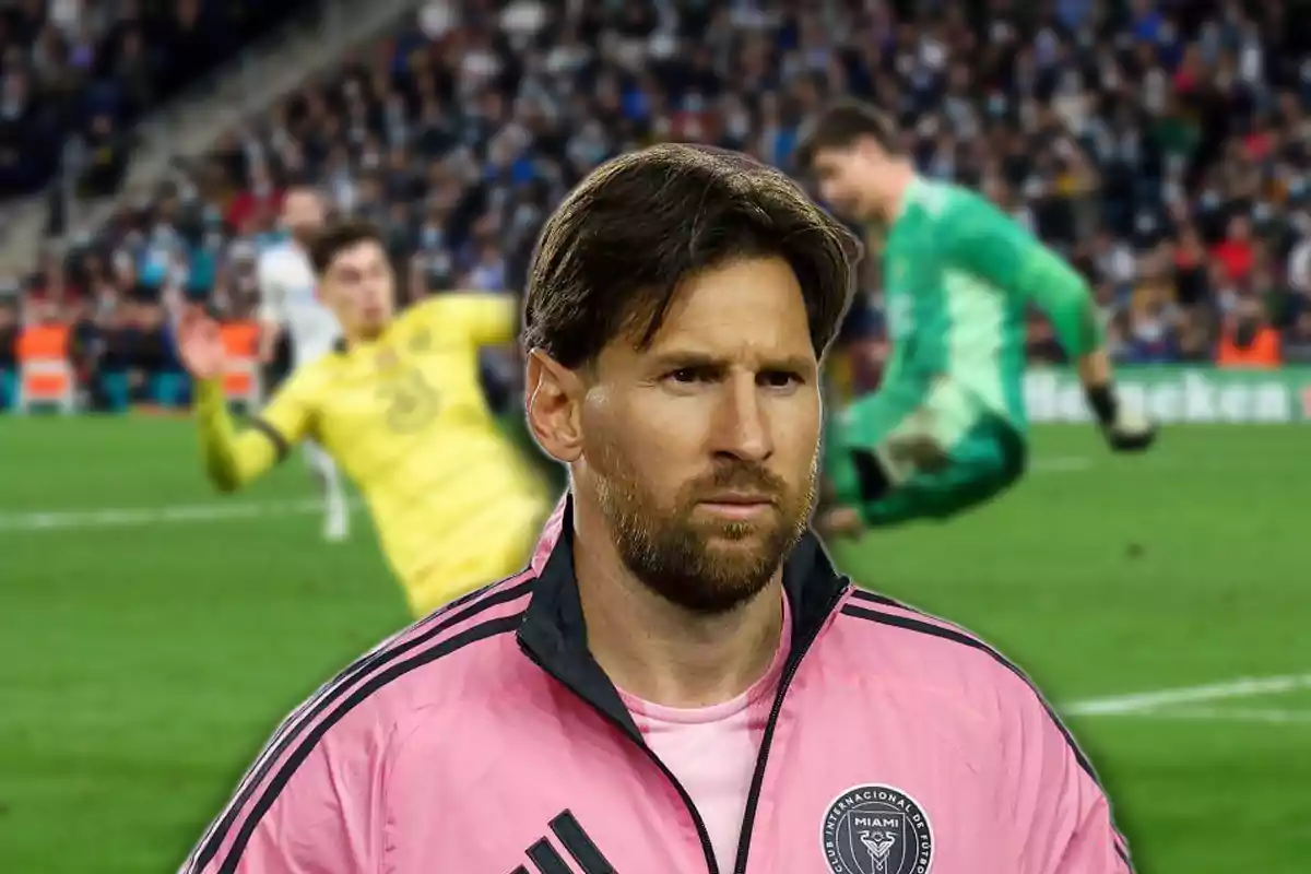 Un futbolista con chaqueta rosa del Inter Miami aparece en primer plano con expresión seria mientras en el fondo se observa una jugada de fútbol con dos porteros en acción y público en las gradas