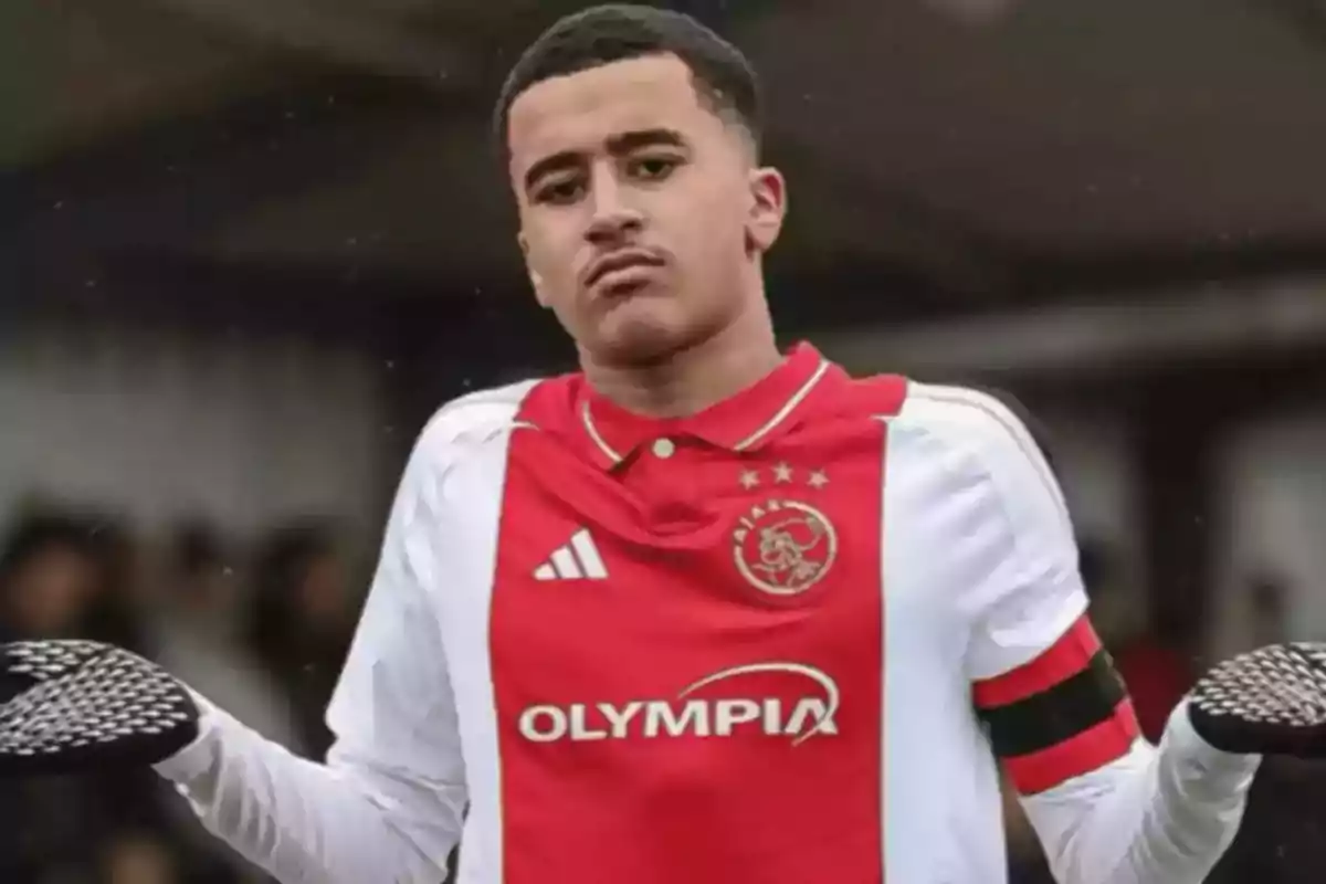 Joven futbolista con uniforme del Ajax haciendo un gesto de encogerse de hombros