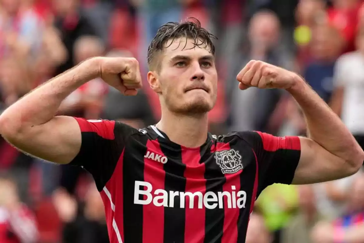 Futbolista con uniforme del Bayer Leverkusen celebrando y mostrando los músculos de ambos brazos Futbolista con uniforme del Bayer Leverkusen celebrando y mostrando los músculos de ambos brazos