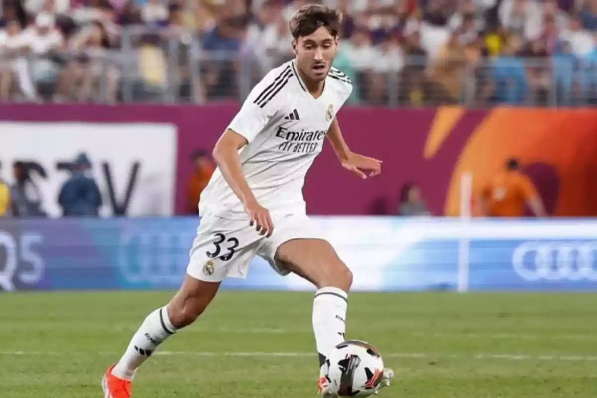 Futbolista del Real Madrid con el número 33 controla el balón durante un partido en un estadio lleno de espectadores Futbolista del Real Madrid con el número 33 controla el balón durante un partido en un estadio lleno de espectadores