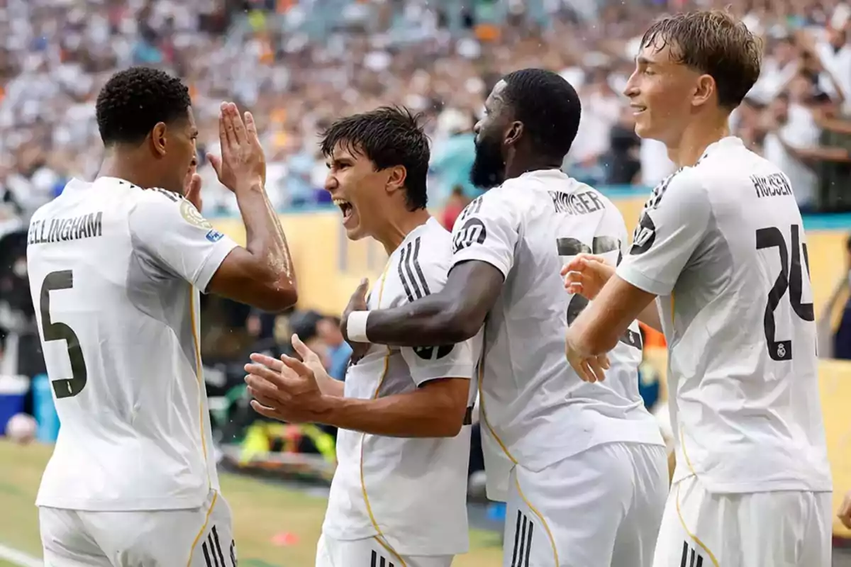 Real Madrid players celebrate a goal on the field during a match, showing excitement and teamwork.