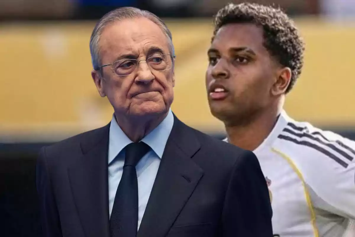 Hombre de traje y gafas al frente con expresión seria y joven futbolista al fondo con uniforme blanco