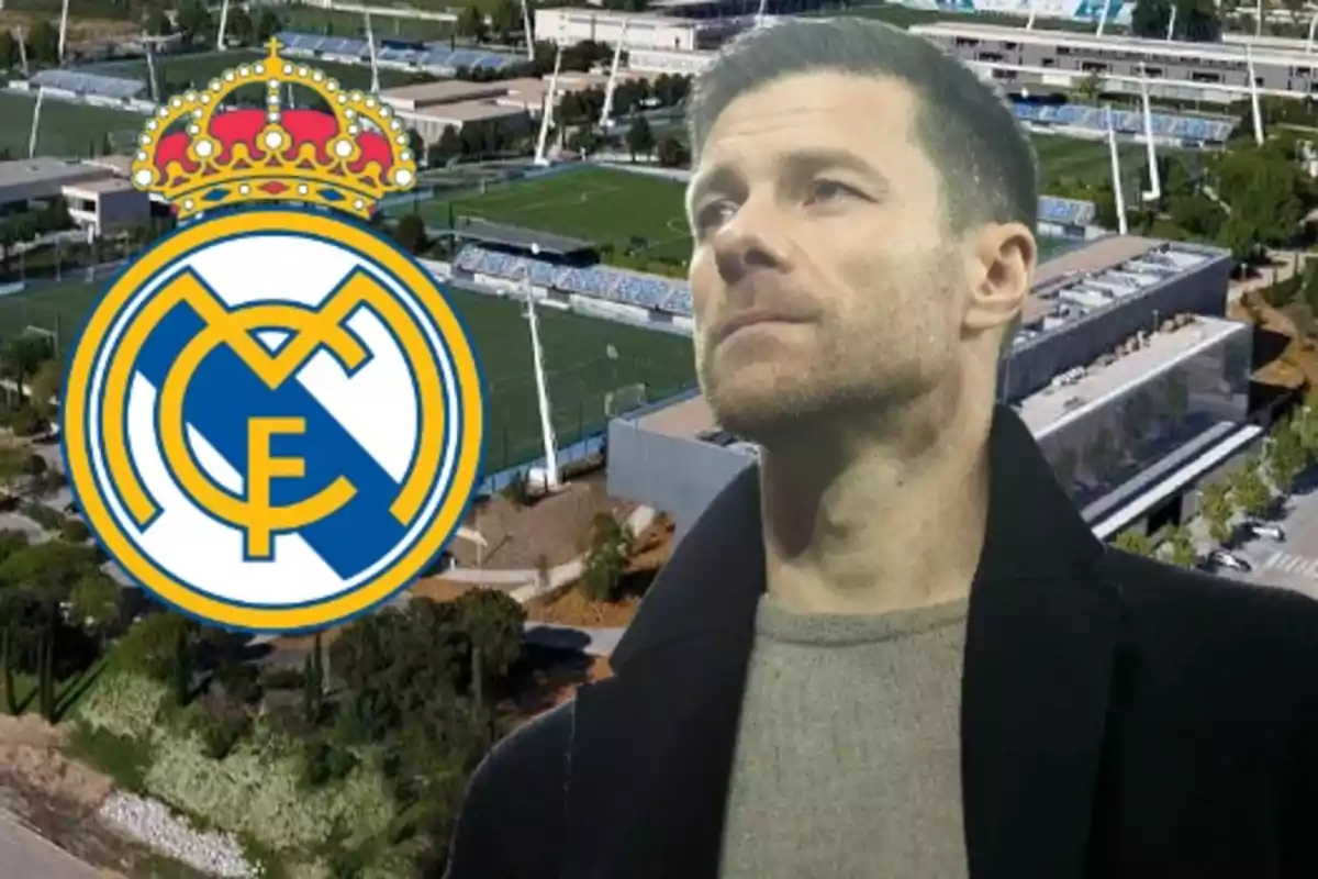 Hombre de cabello corto con expresión seria frente a un campo de entrenamiento y el escudo del Real Madrid