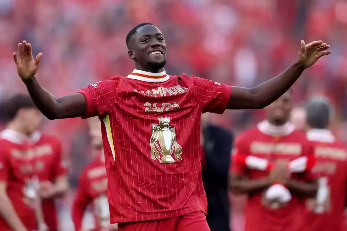 Soccer player celebrating with arms outstretched, wearing a red champion jersey with the text Soccer player celebrating with arms outstretched, wearing a red champion jersey with the text