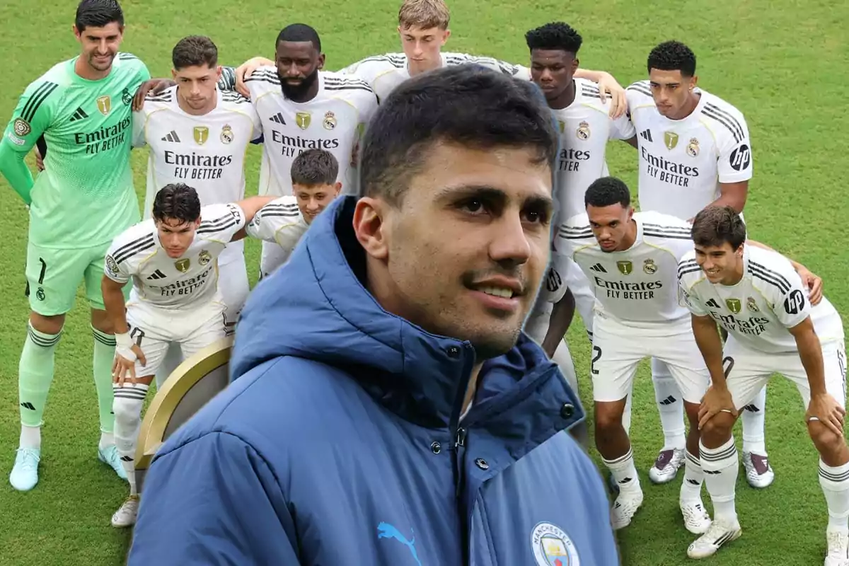A player in a blue Manchester City jacket appears in the foreground in front of a group of Real Madrid footballers posing on the field.