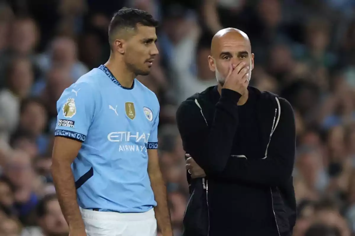 Jugador del Manchester City conversando con su entrenador durante un partido de fútbol Jugador del Manchester City conversando con su entrenador durante un partido de fútbol
