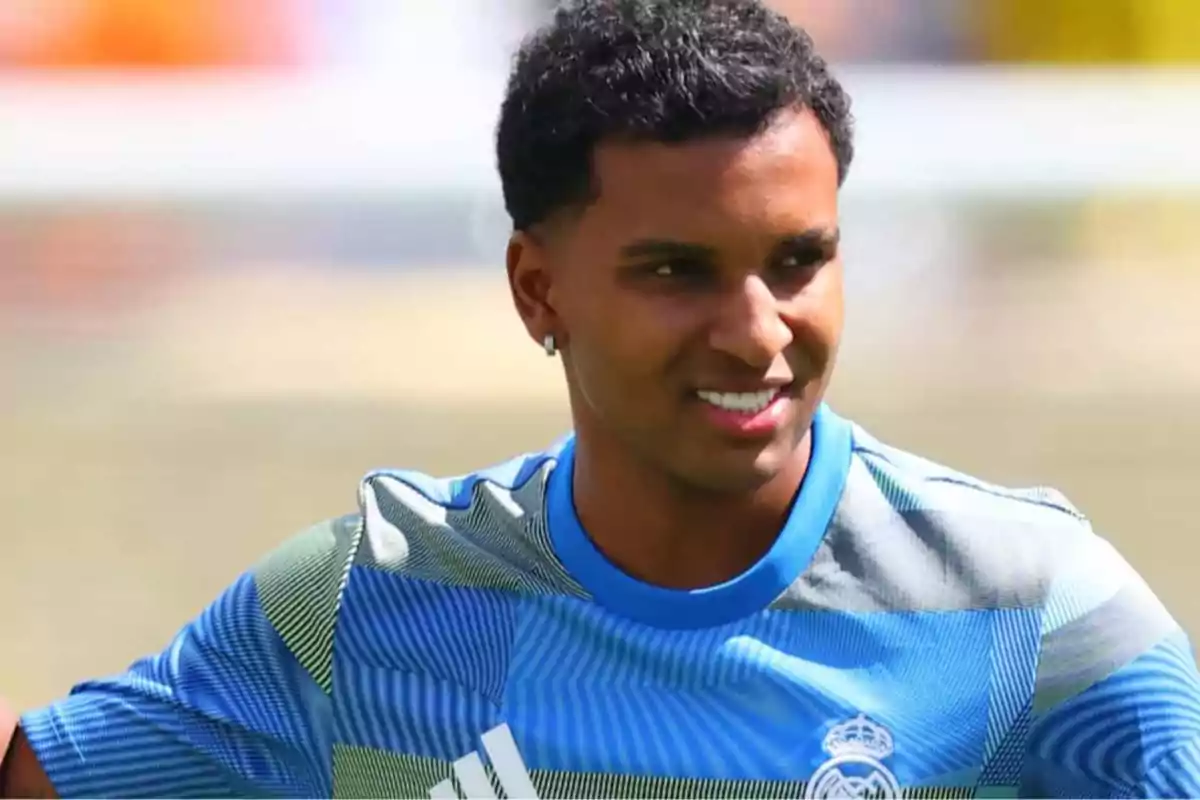 Jugador de fútbol con camiseta de entrenamiento azul del Real Madrid sonríe durante una práctica al aire libre Jugador de fútbol con camiseta de entrenamiento azul del Real Madrid sonríe durante una práctica al aire libre