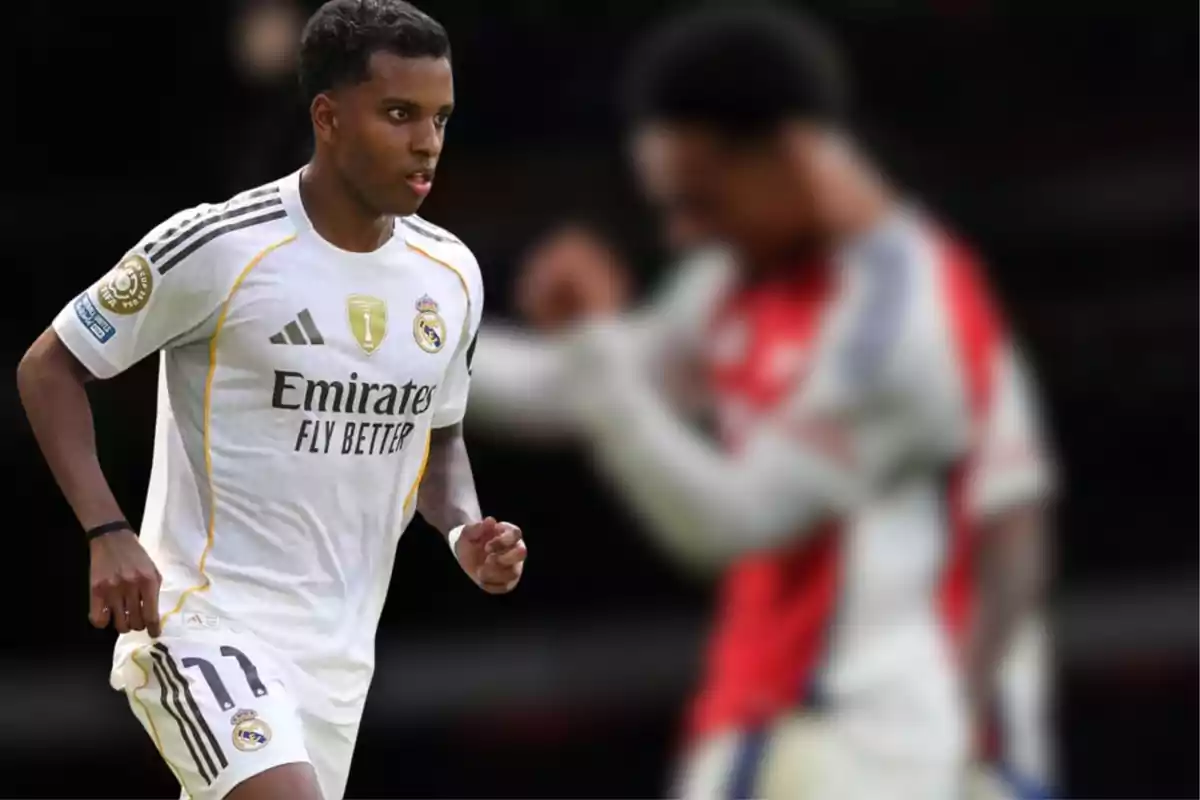 Futbolista del Real Madrid con uniforme blanco en primer plano mientras un jugador rival aparece desenfocado al fondo
