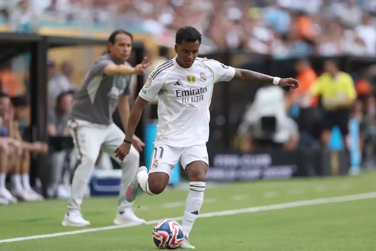 Real Madrid player controlling the ball during a match while a coach gives instructions from the sideline Real Madrid player controlling the ball during a match while a coach gives instructions from the sideline