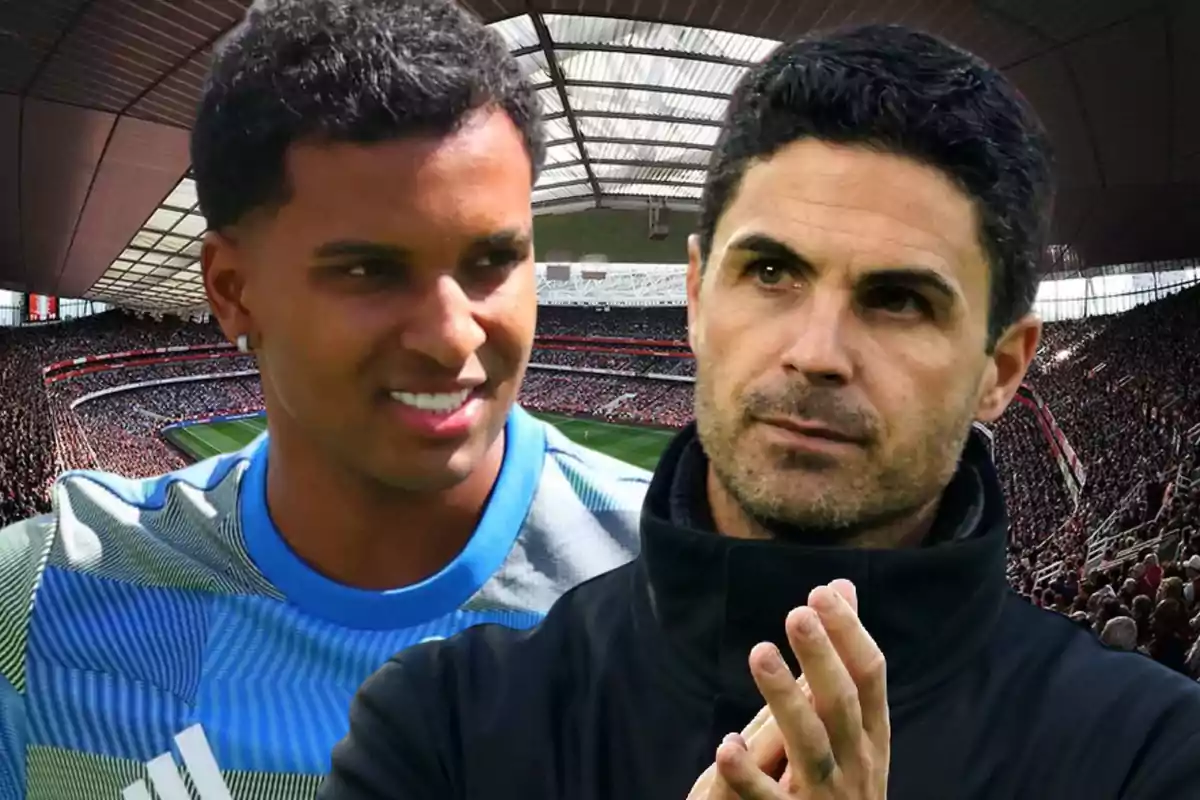 Dos hombres en primer plano dentro de un estadio de fútbol lleno de espectadores uno de ellos lleva una camiseta deportiva y el otro viste ropa oscura
