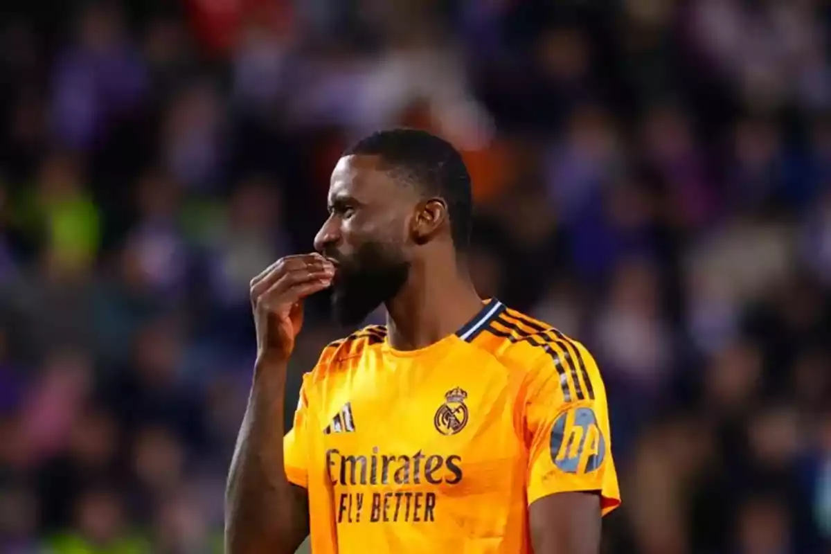 Futbolista del Real Madrid con uniforme naranja llevándose la mano a la boca durante un partido Futbolista del Real Madrid con uniforme naranja llevándose la mano a la boca durante un partido