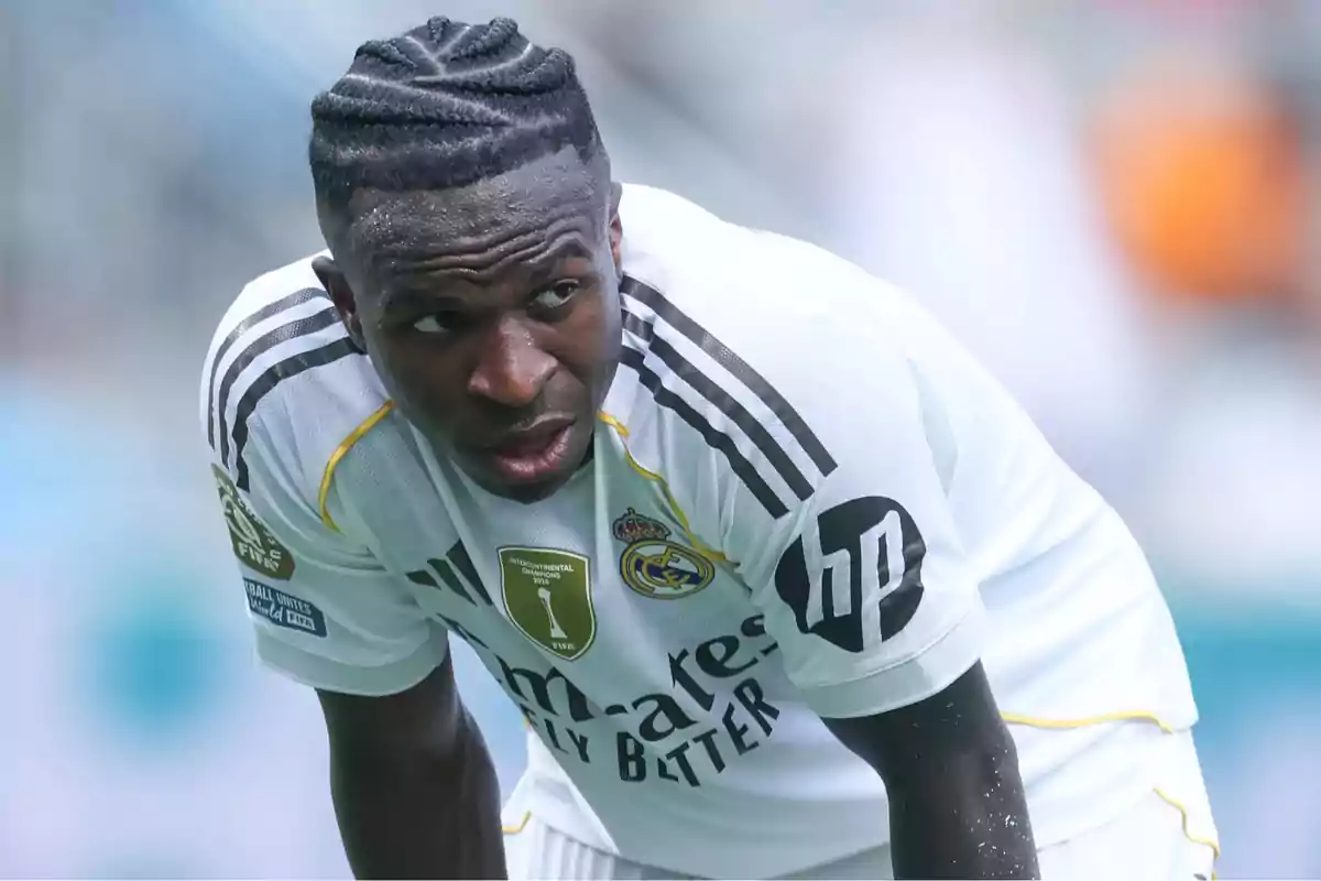 Futbolista del Real Madrid con uniforme blanco inclinado hacia adelante durante un partido