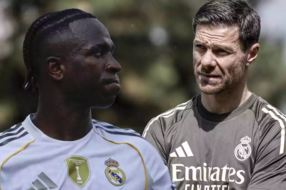 Two men in Real Madrid uniforms looking at each other with serious expressions in an outdoor setting