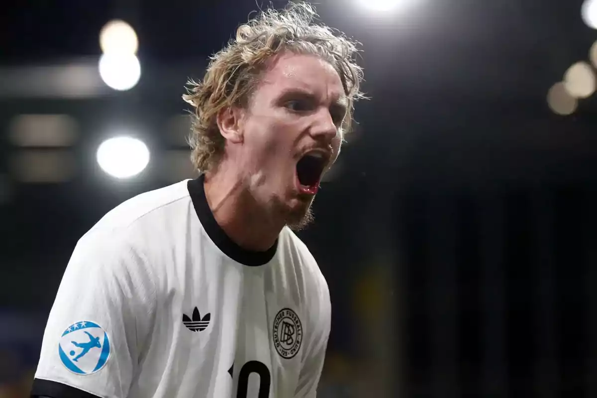 Soccer player in a white jersey shouting with an expression of euphoria during a match Soccer player in a white jersey shouting with an expression of euphoria during a match