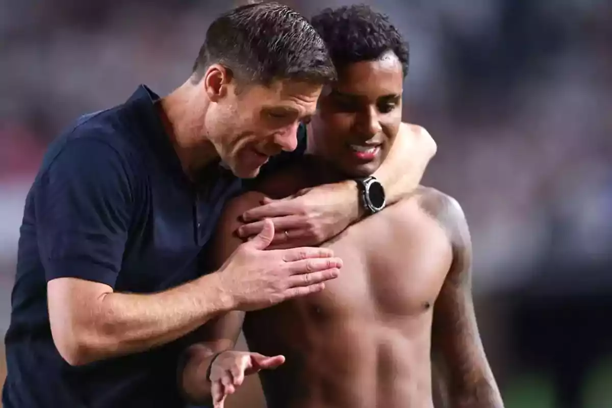 Entrenador abraza y motiva a un futbolista sin camiseta en el campo de juego Entrenador abraza y motiva a un futbolista sin camiseta en el campo de juego