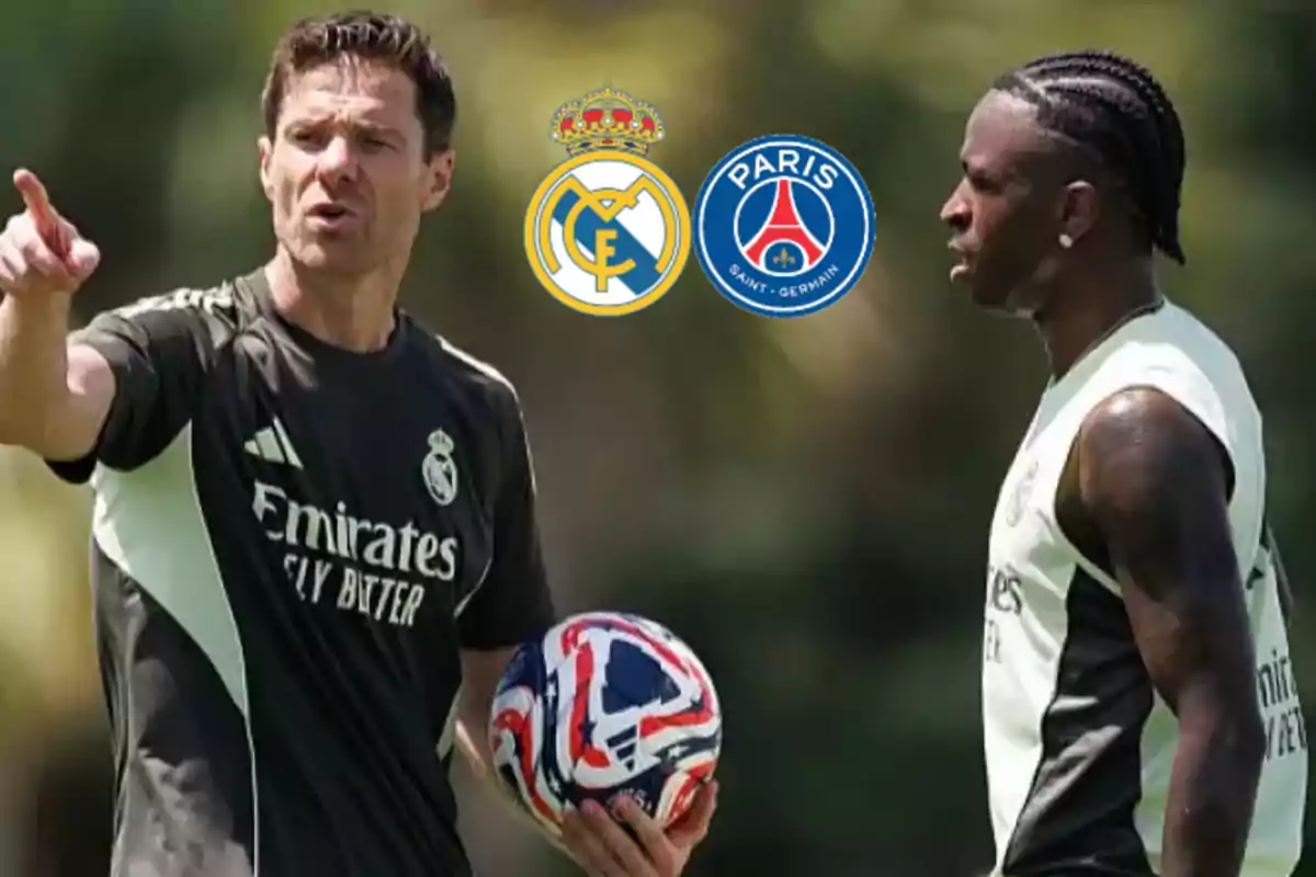 Real Madrid coach and player talking during a training session with the Real Madrid and PSG crests in the background