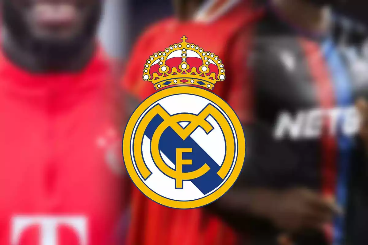 Escudo del Real Madrid en el centro de la imagen con fondo desenfocado de jugadores de fútbol con uniformes rojos y oscuros