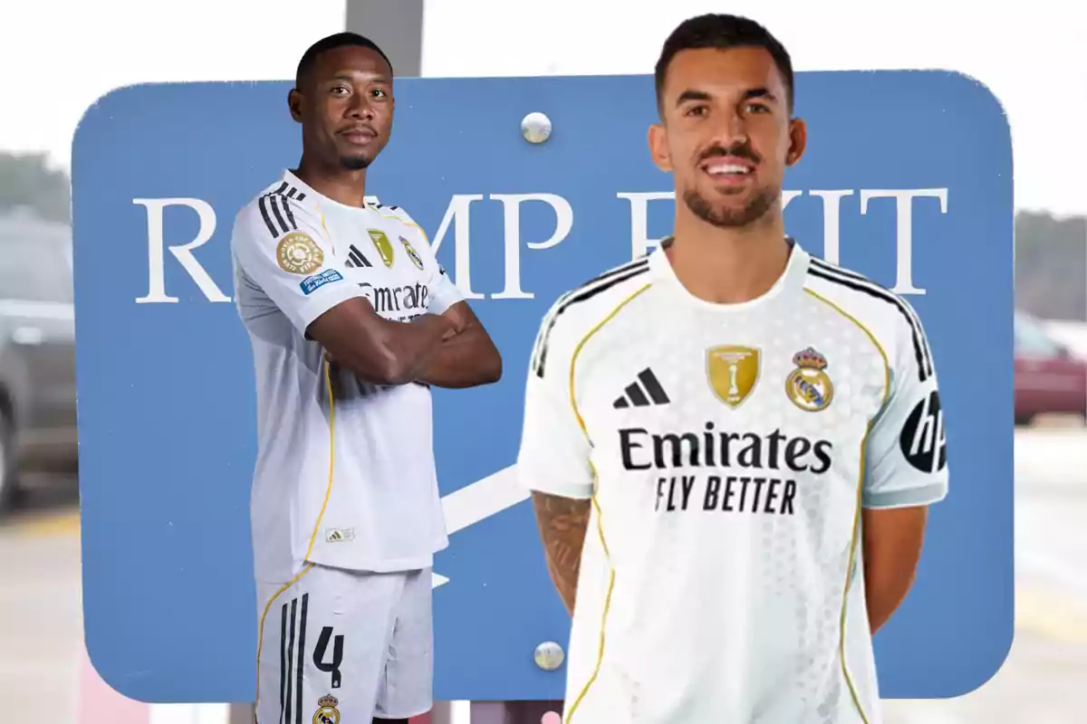 Two Real Madrid players pose in front of a blue sign with partially visible white letters.