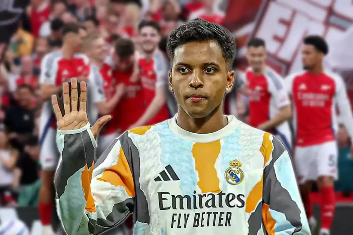 Un futbolista con uniforme del Real Madrid levanta la mano mientras al fondo se ven jugadores del Arsenal celebrando.