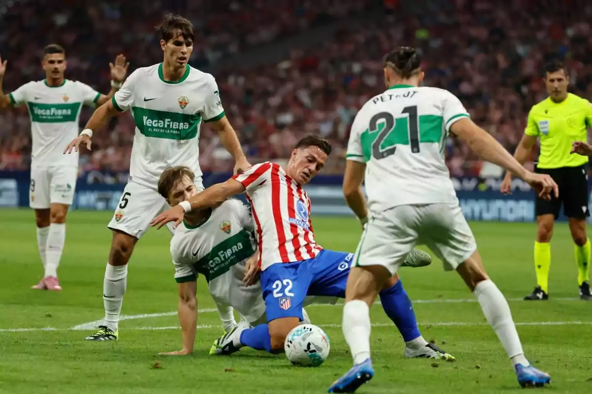 Jugadores de fútbol disputan el balón durante un partido mientras un árbitro observa la jugada en el fondo Jugadores de fútbol disputan el balón durante un partido mientras un árbitro observa la jugada en el fondo