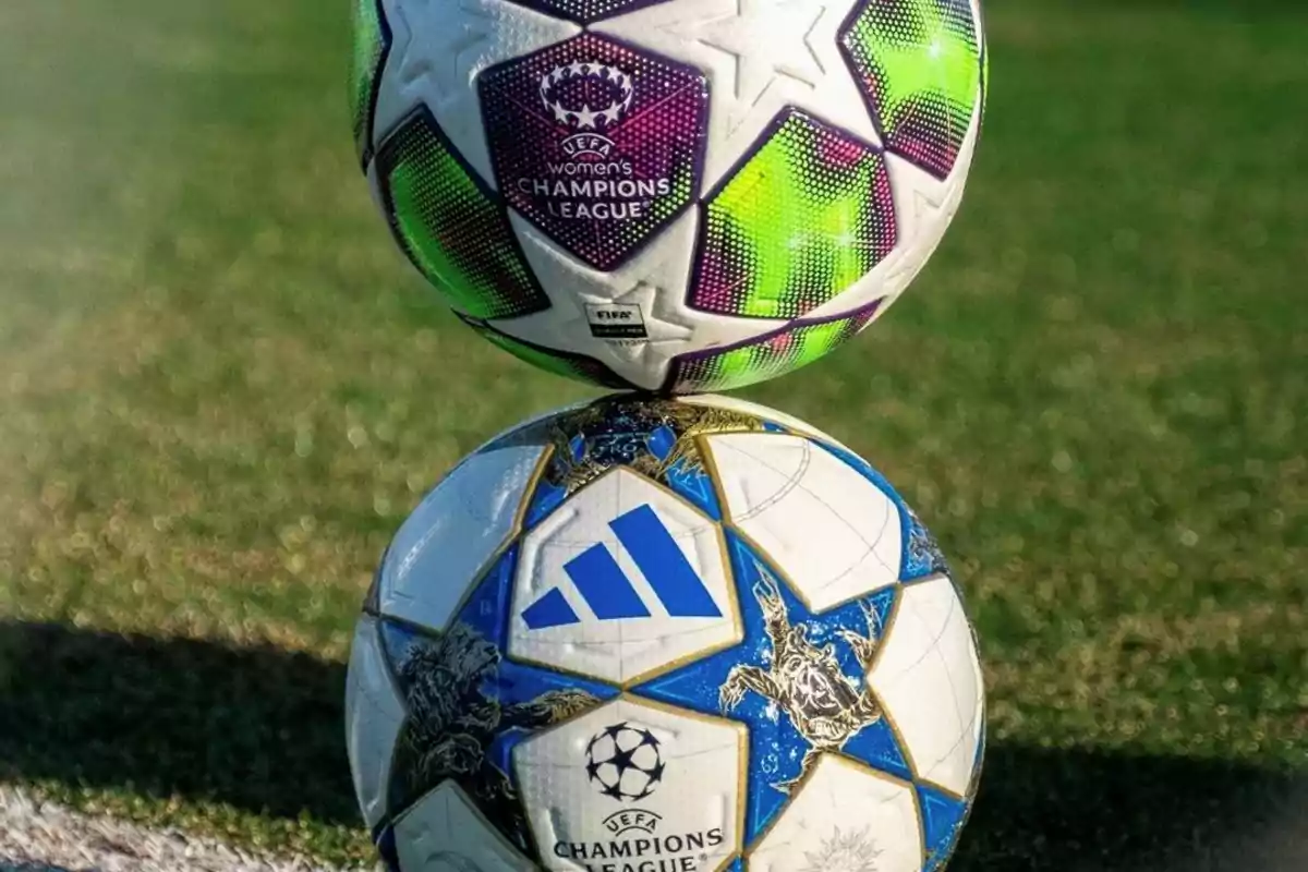 Two official Champions League balls, one from the women's edition and one from the men's, stacked on the grass. Two official Champions League balls, one from the women's edition and one from the men's, stacked on the grass.