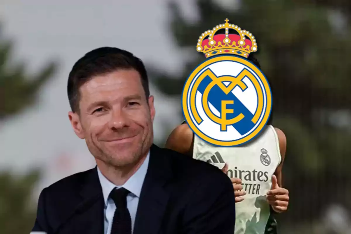 Hombre sonriente con traje junto a una persona con el escudo del Real Madrid cubriendo su rostro