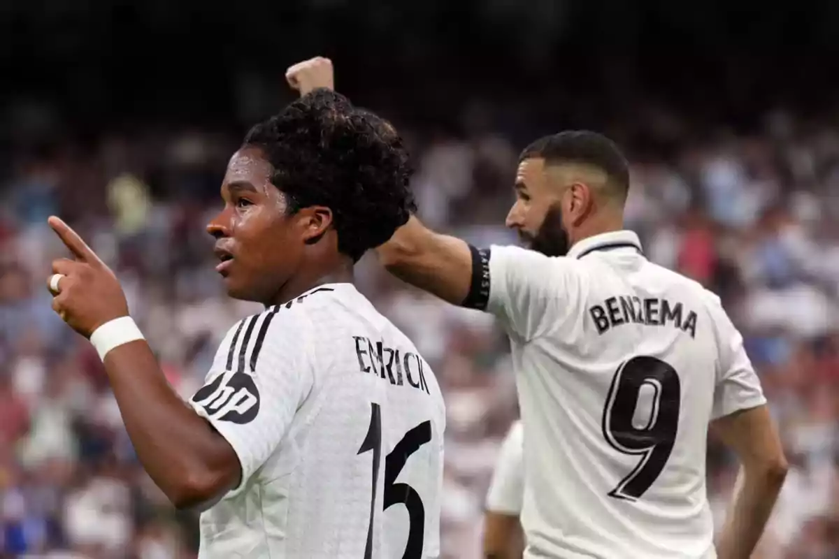 Dos futbolistas con uniforme blanco celebran en un estadio lleno, uno de ellos lleva el nombre Endrick y el número 15, el otro lleva el nombre Benzema y el número 9.