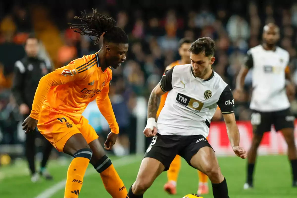 Two players compete for the ball during a match between Real Madrid and Valencia. Two players compete for the ball during a match between Real Madrid and Valencia.