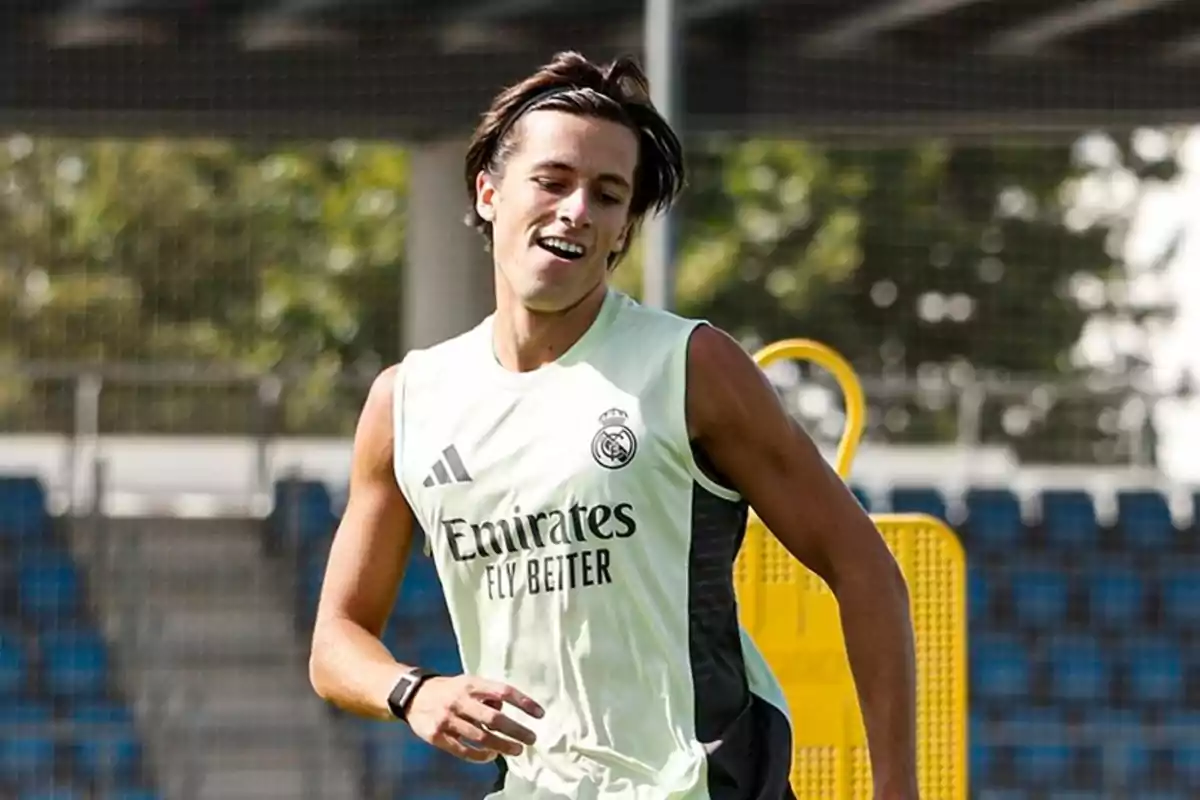 Joven futbolista entrenando con camiseta sin mangas del Real Madrid en un campo de fútbol