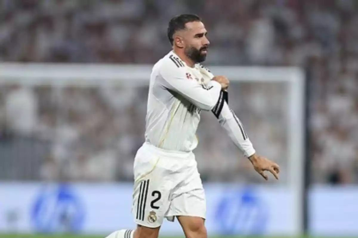 Soccer player in a white uniform on the field adjusting his sleeve during a match Soccer player in a white uniform on the field adjusting his sleeve during a match