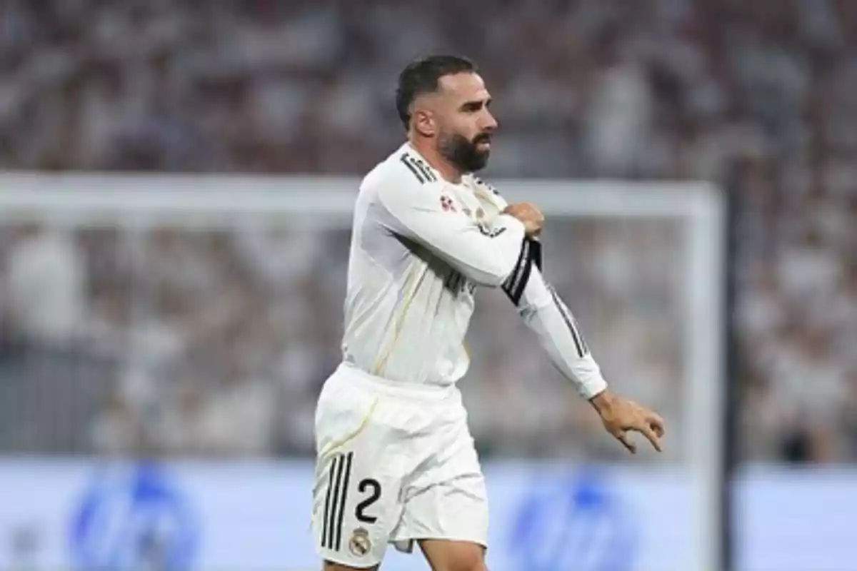 Soccer player in a white uniform on the field adjusting the captain's armband during a match Soccer player in a white uniform on the field adjusting the captain's armband during a match