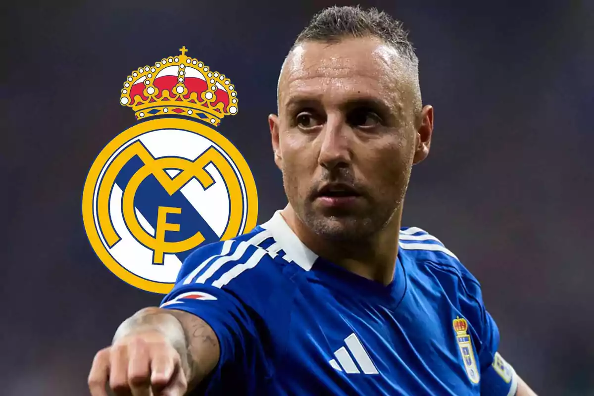 Soccer player in a blue uniform pointing forward with the Real Madrid crest in the background