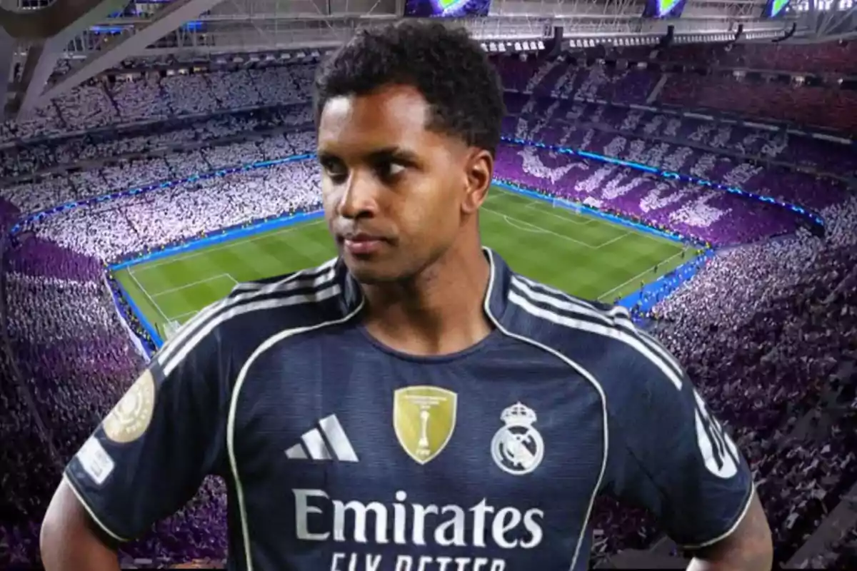 Real Madrid player in a dark blue uniform posing in a stadium full of fans with a mosaic in the stands