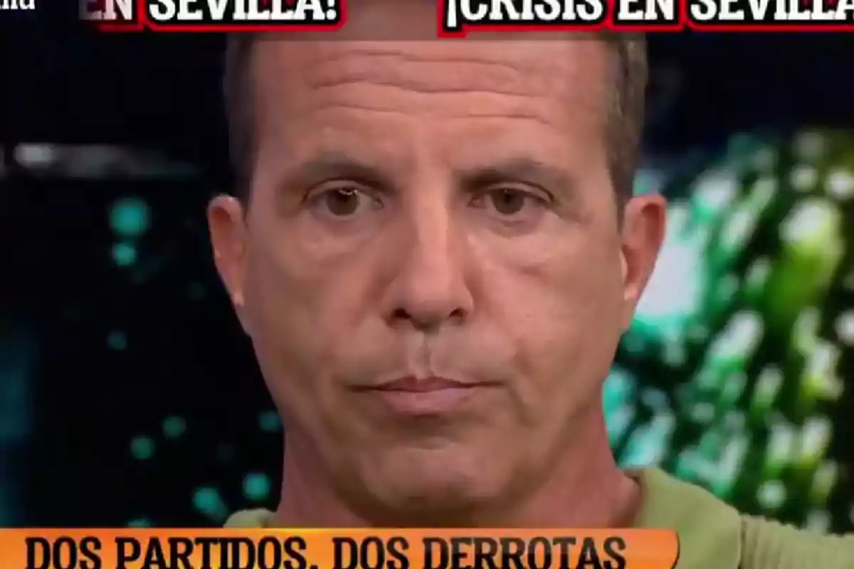 Man with a serious expression on a television program with headlines about a crisis in Seville and two sports defeats