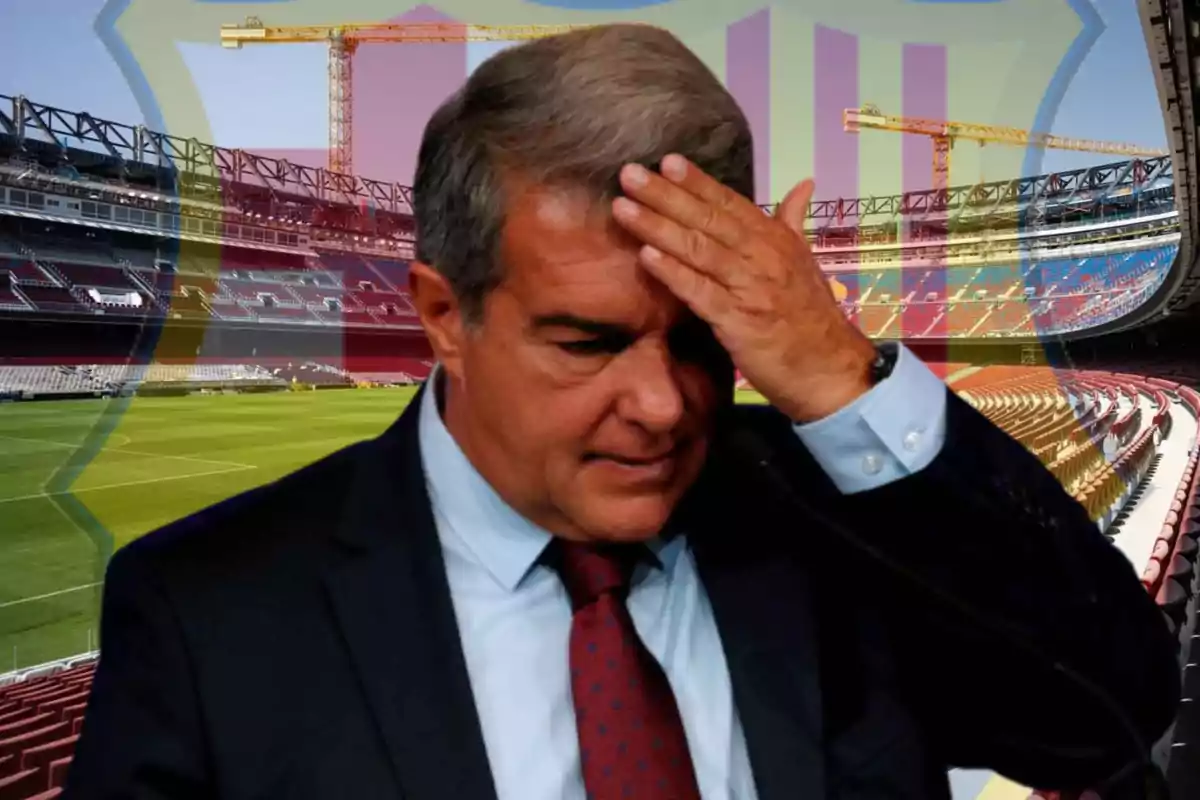Man with a worried expression in a football stadium under renovation, with the blurred FC Barcelona crest in the background