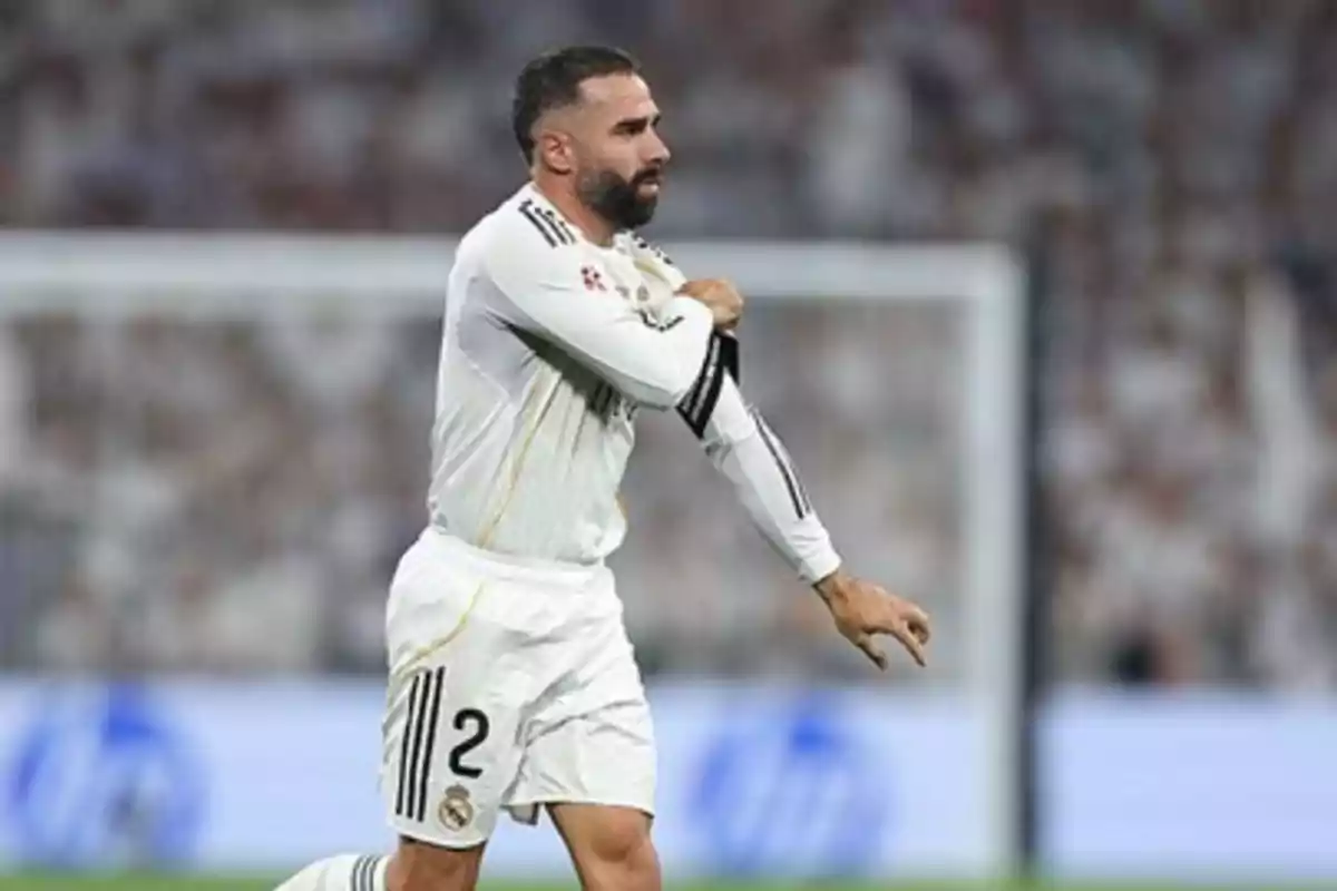 Soccer player in a white uniform on the field adjusting his sleeve during a match Soccer player in a white uniform on the field adjusting his sleeve during a match