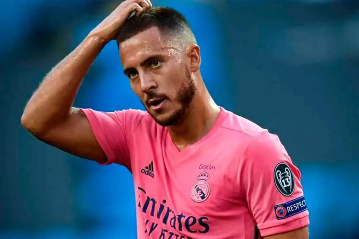 Futbolista con camiseta rosa del Real Madrid tocándose la cabeza durante un partido