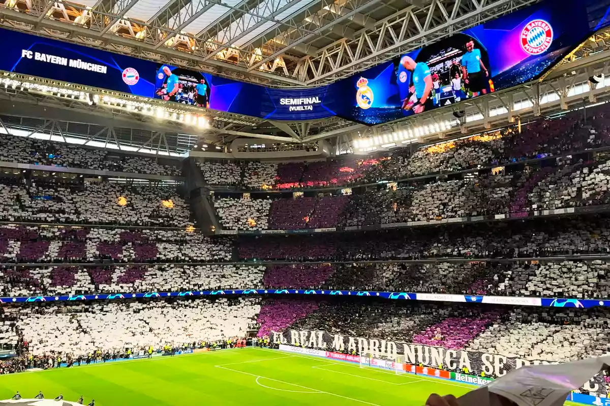 Estadio lleno de aficionados mostrando un mosaico en las gradas durante una semifinal de fútbol entre Real Madrid y Bayern Múnich con un mensaje de apoyo al equipo local Estadio lleno de aficionados mostrando un mosaico en las gradas durante una semifinal de fútbol entre Real Madrid y Bayern Múnich con un mensaje de apoyo al equipo local