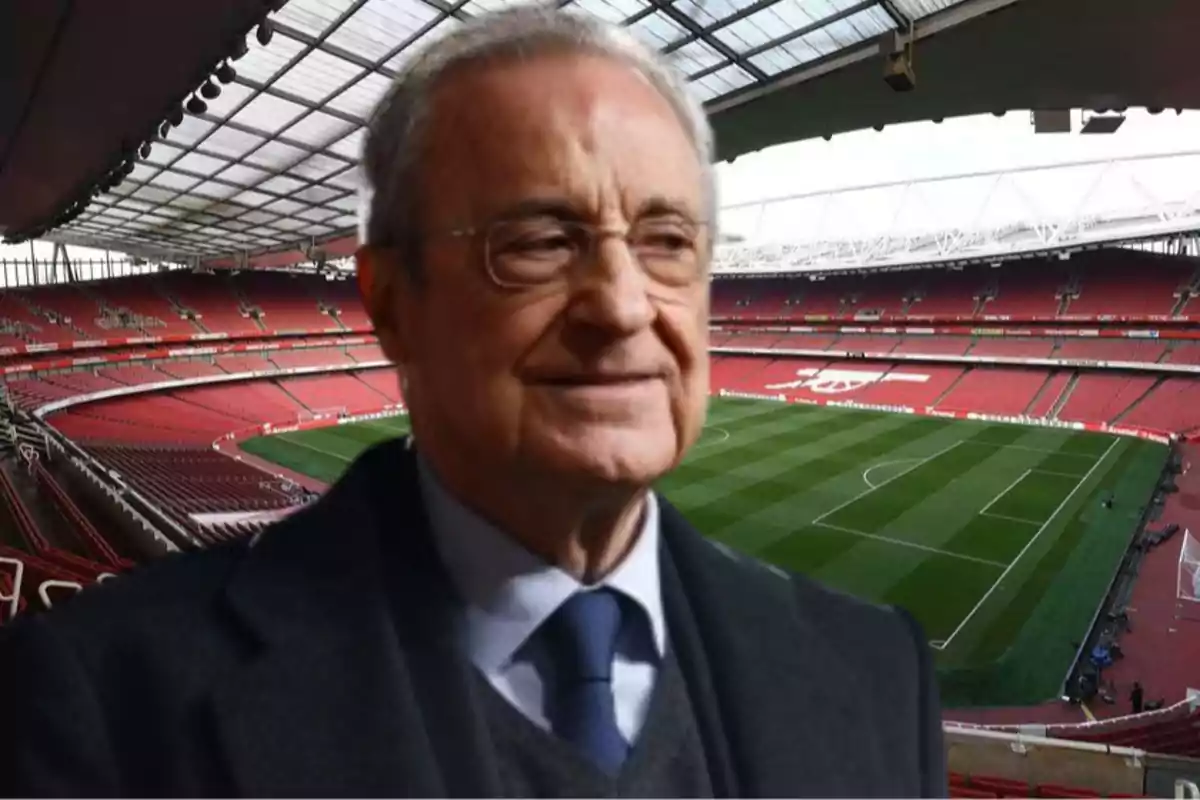 Hombre mayor con gafas y traje oscuro en primer plano con un estadio de fútbol vacío al fondo