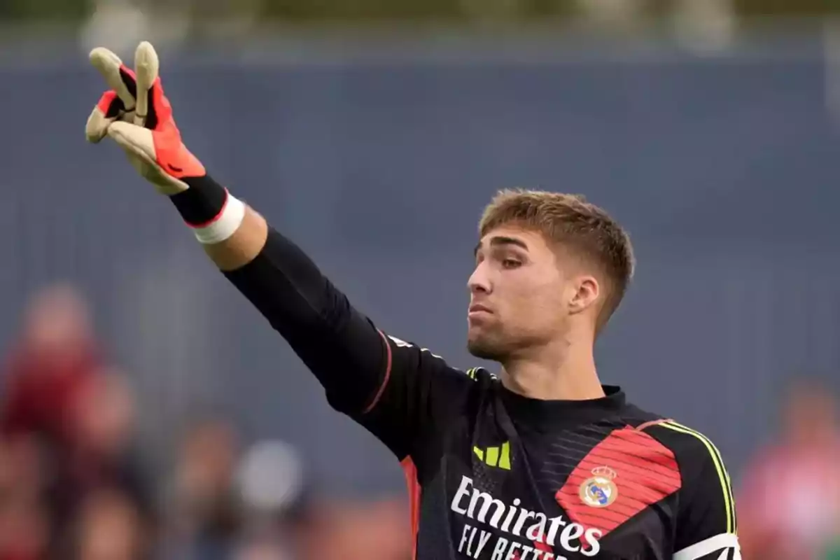 Real Madrid goalkeeper in a black uniform and gloves pointing with his hand during a soccer match Real Madrid goalkeeper in a black uniform and gloves pointing with his hand during a soccer match