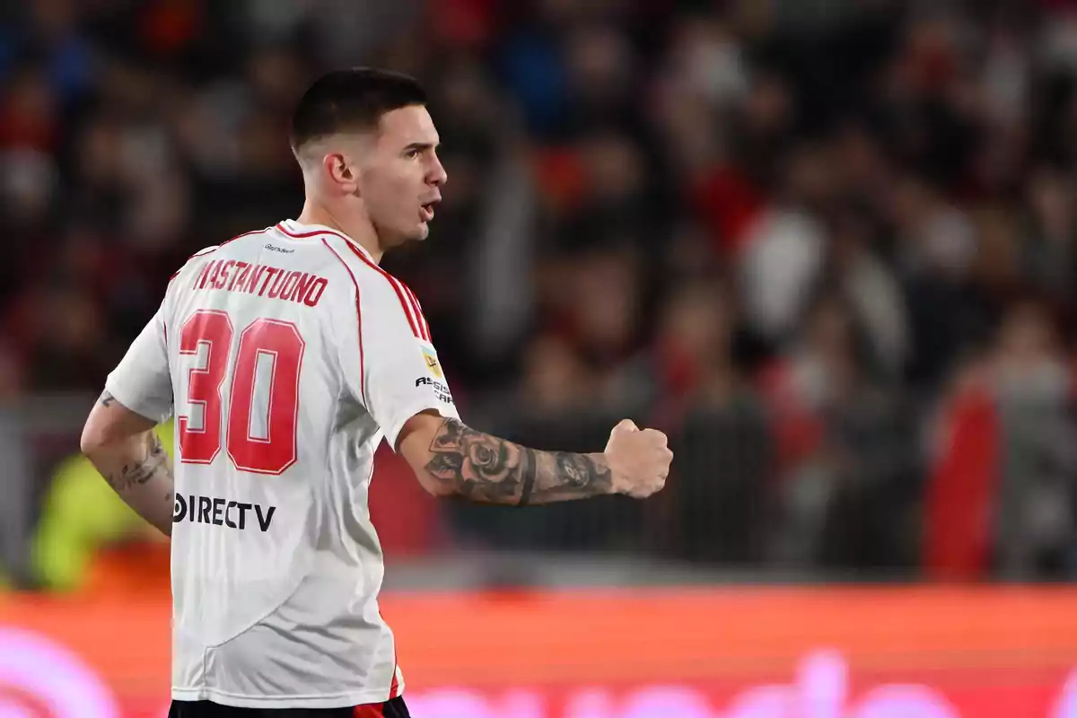 Soccer player wearing a white jersey with the number 30 celebrating in a stadium full of spectators Soccer player wearing a white jersey with the number 30 celebrating in a stadium full of spectators