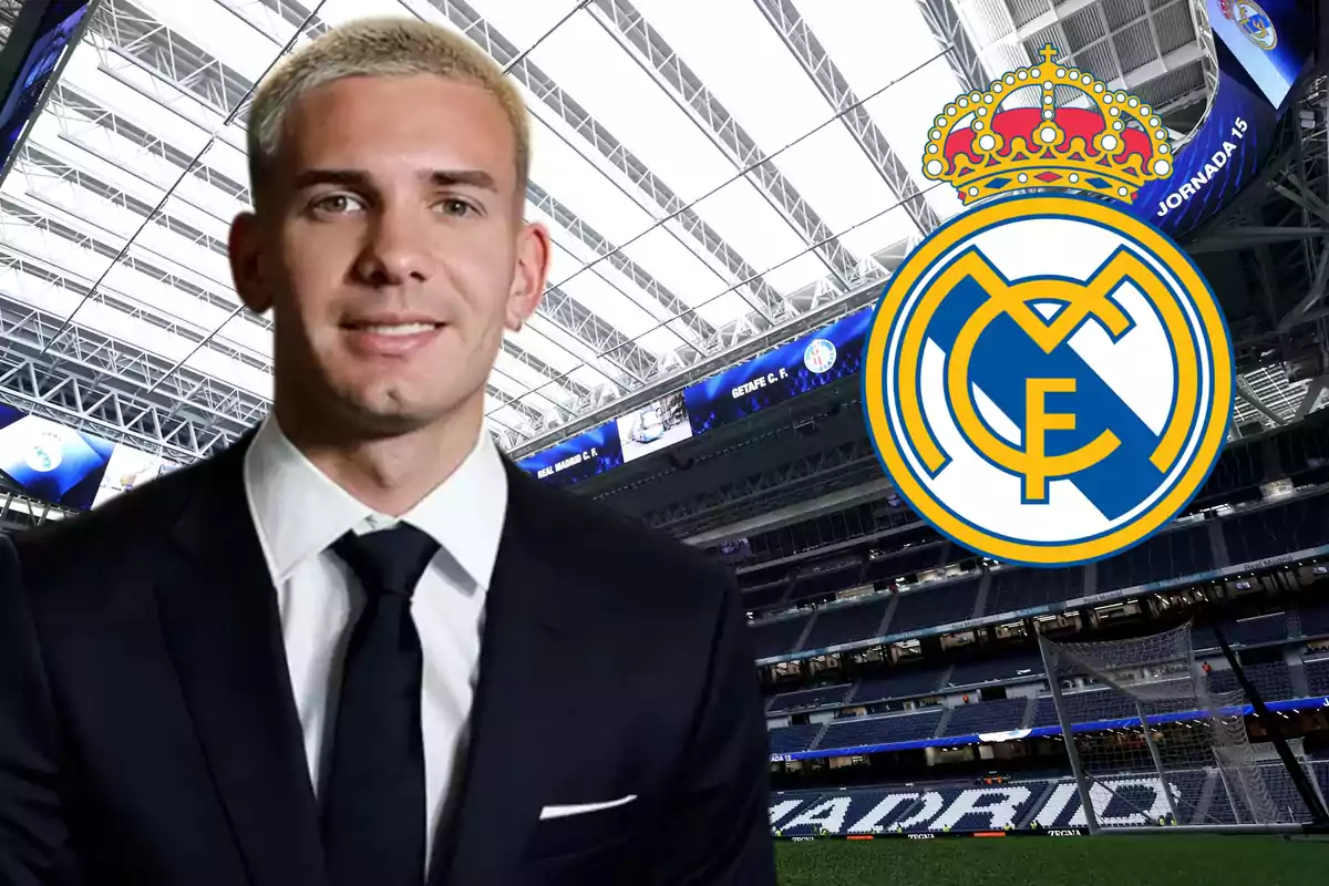 Un hombre con traje sonríe en un estadio de fútbol con el escudo del Real Madrid al fondo