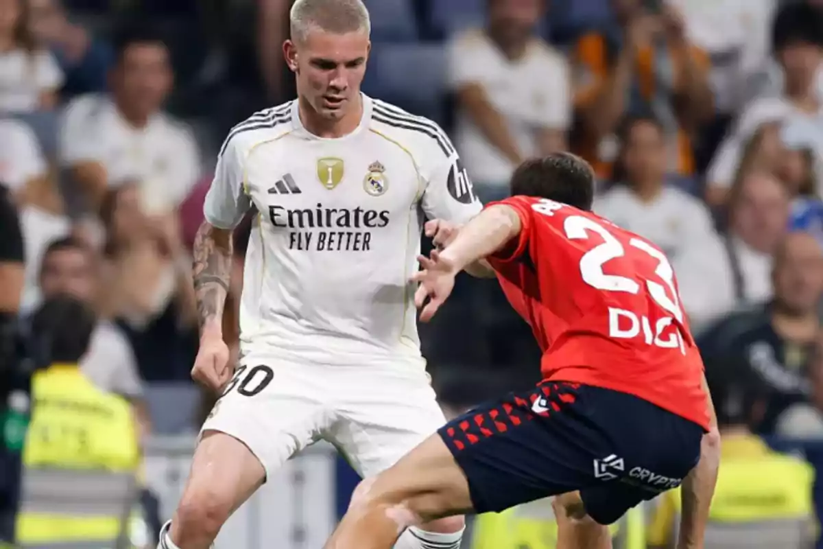 Two players compete for the ball during a match, one wearing a white uniform and the other wearing a red uniform. Two players compete for the ball during a match, one wearing a white uniform and the other wearing a red uniform.