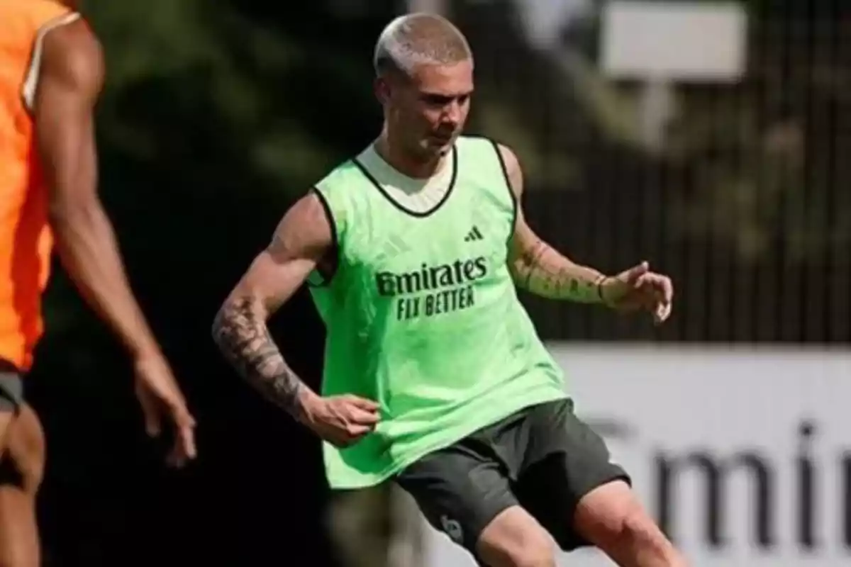 Soccer player training on the field wearing a green bib, with the ball out of frame Soccer player training on the field wearing a green bib, with the ball out of frame